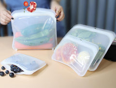 Food grade reusable silicone food bags filled with fresh vegetables, fruit, and snacks to keep them fresh.