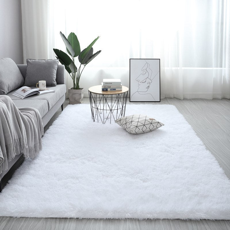 Plush white nordic fluffy bedroom rug in a modern living room setting with a grey sofa and minimalist decor.