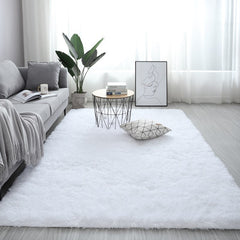 Plush white nordic fluffy bedroom rug in a modern living room setting with a grey sofa and minimalist decor.