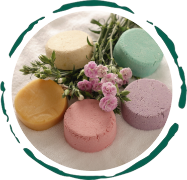 Colorful plastic-free shampoo bar assortment with flowers, showcasing all-natural ingredients and handmade quality.