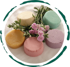 Colorful plastic-free shampoo bar assortment with flowers, showcasing all-natural ingredients and handmade quality.