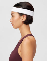 Nike Swoosh classic headband worn by a woman, showing absorbent terry design in white color.