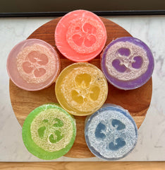 natural loofah soap bar colorful variety displayed on a wooden plate