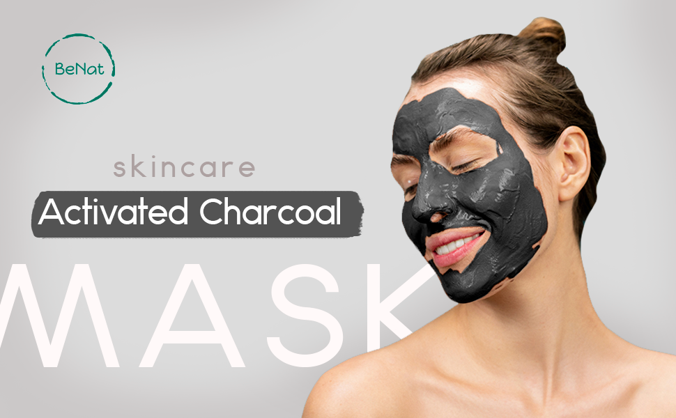 Woman applying activated charcoal face mask for a rejuvenating skincare treatment and radiant complexion.