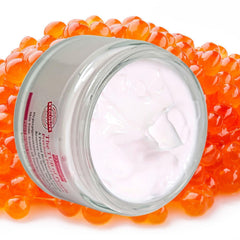 brightening face cream for radiant skin in a clear tub on an orange bead background