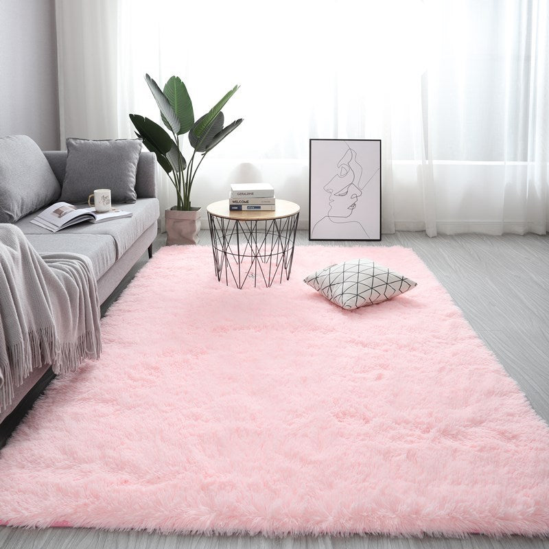 Plush light pink nordic fluffy bedroom rug styled in a modern minimalist living room next to a grey couch.