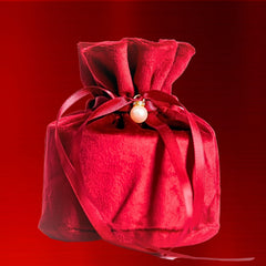 brightening face cream for radiant skin elegantly wrapped in a red pouch with a pearl embellishment.