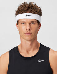 Nike Swoosh classic headband worn by a male model with short, curly hair and a black tank top.