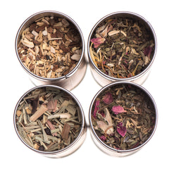 Ayurvedic herbal tea collection in stainless steel tins featuring various organic herbs and floral blends.