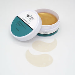 24k golden eye patches in open jar with patches on white surface