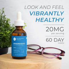 spermidine drops supplement in a dropper bottle with 20mg per serving on a wooden surface, beside glasses and greenery.