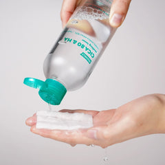 Person pouring FRANKLY CICA 80 & Hyaluronic Acid Toner for sensitive skin onto a cotton pad.