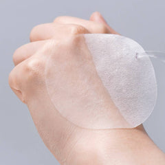 Hand holding a FRANKLY pore tightening toner pad showcasing its lightweight, translucent design for skincare.