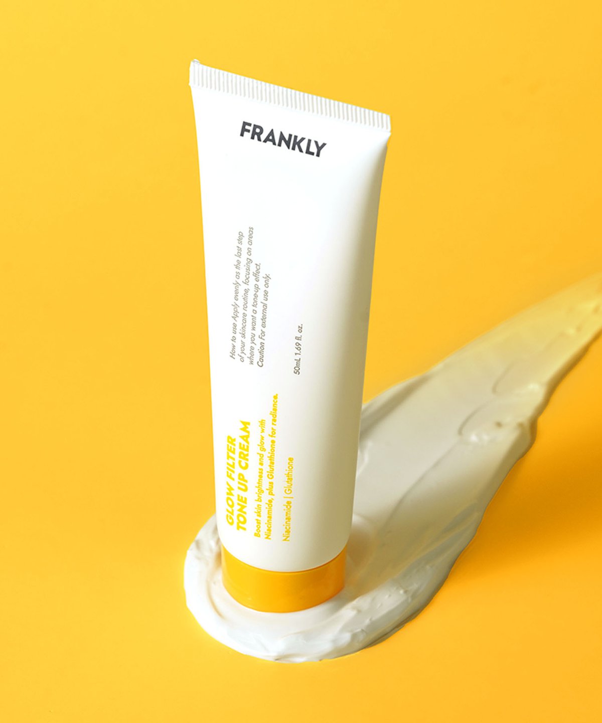 FRANKLY Glow Filter Tone Up Cream tube on a yellow background, promoting tone up cream for glowing skin.