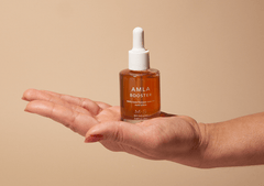 ayurvedic amla oil for face and hair bottle held in hand