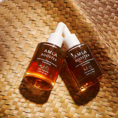 ayurvedic amla oil for face and hair two bottles on woven background