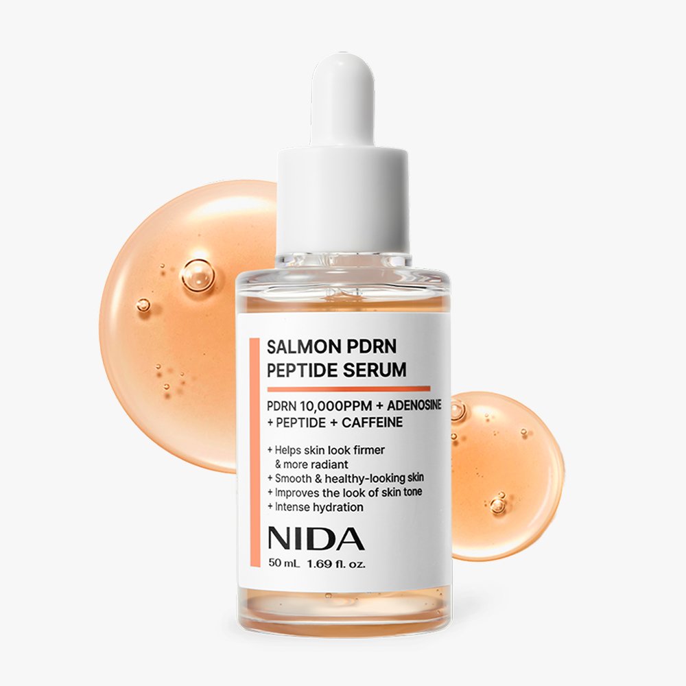 NIDA Salmon PDRN serum in a glass dropper bottle, surrounded by serum droplets, promoting radiant and firm skin.