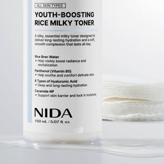 NIDA Youth-Boosting Rice Milky Toner 150ml bottle with cotton pads in the background, showcasing hydrating properties.